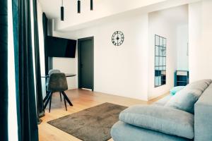 a living room with a couch and a clock on the wall at Cremene Tower ApartHotel in Cluj-Napoca +31 photos