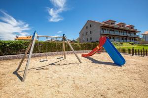 a playground with a swing set in the sand at Apartamentos Eira Do Mar Sanxenxo in Aios