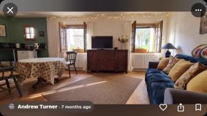a living room with a couch and a tv at Jasmin 1 Jeanne d Albret in Navarrenx
