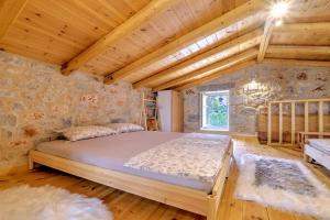 a bedroom with a large bed in a stone wall at Crown House in Areopolis in Areopoli
