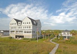 una gran casa blanca en la cima de un exuberante campo verde en Elizabeth Pointe Lodge, en Fernandina Beach