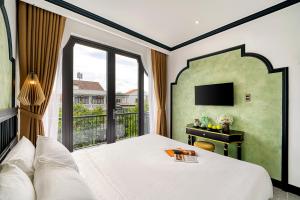 Postel nebo postele na pokoji v ubytování Rokas Hoi An Boutique Hotel