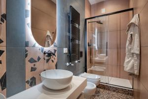 a bathroom with a bowl sink and a toilet at Via Fiasella - Le Case di Bart in Genoa