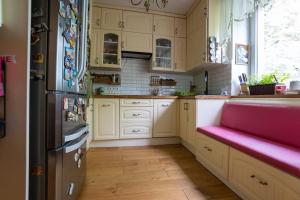 a kitchen with white cabinets and a pink bench at Solne Apartamenty Luna 3 in Wieliczka