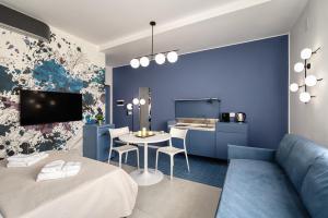 a room with a bed and a table and a kitchen at Via Fiasella - Le Case di Bart in Genoa