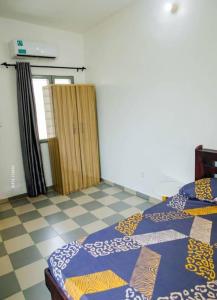 a room with two beds and a door to a room at Appartement "Blessed Kingdom" in Cotonou
