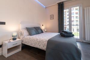 ein weißes Schlafzimmer mit einem Bett und einem Fenster in der Unterkunft Forum Evolucion Residence in Burgos