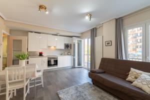 ein Wohnzimmer mit Couch und Küche in der Unterkunft Forum Evolucion Residence in Burgos