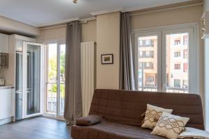 ein Wohnzimmer mit einem Sofa und großen Fenstern in der Unterkunft Forum Evolucion Residence in Burgos