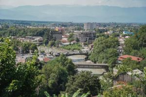 a cityscape of a city with a river and buildings at Old district in Kutaisi