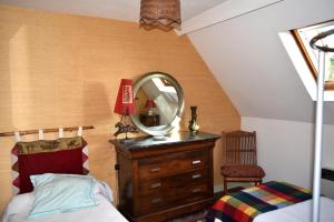 a bedroom with a bed and a mirror on a dresser at Maison derrière les champs in Itteville