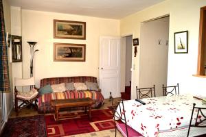 a living room with a couch and a bed at Maison derrière les champs in Itteville