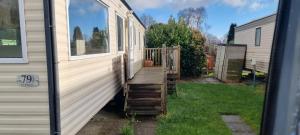 a porch with a wooden staircase next to a house at Caravan - Sleeps 8 pet friendly & hot tub in Welshpool