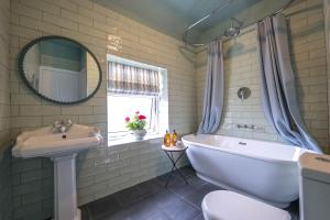 une salle de bain avec une baignoire blanche et un lavabo dans l'établissement Large Country Cottage, Sleeps 8 - Spa Facilities, Garden Bar, Catering Services, Free Parking, Nature Reserve, Hen Parties, à Scunthorpe