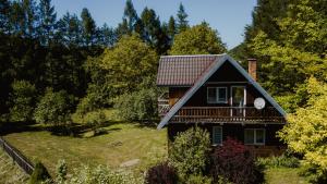 a house with a gambrel roof on a yard at Domki u Serowarki z Jacuzzi w cenie in Polańczyk