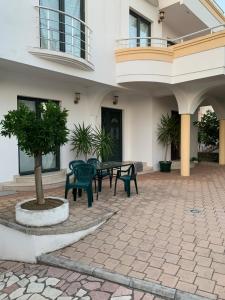 Un patio con una mesa y sillas frente a un edificio. en Apartments Boffi, en Ulcinj
