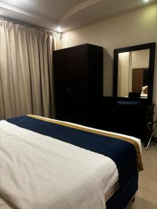 a bedroom with a bed with a mirror and a desk at Ramis Furnished Units in Buraydah