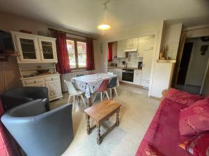 a kitchen with a table and chairs in a room at Gemeaux B, appartement proche pistes de ski et village in La Clusaz