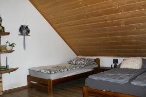 two beds in a room with a wooden ceiling at Siedlisko Magiczne Cimanie in Cimanie