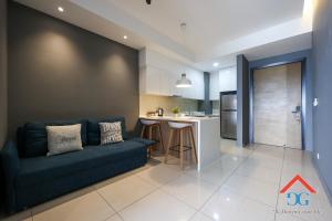 Una sala de estar con un sofá y una cocina. en The Elements by Grabstay, en Kuala Lumpur