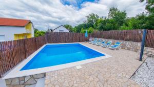 a swimming pool with chairs and a fence at Retro Pool House in Mostar