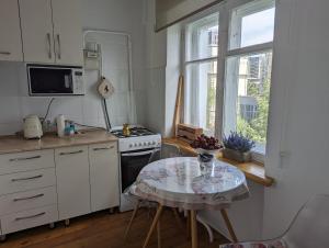 a kitchen with a table and a stove and a window at Moonflower residence 4645 in Bishkek