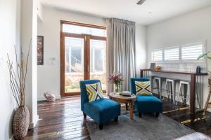 a living room with two blue chairs and a table at Studio South Port - Lush Private Oceanfront Studio Apartment in Port Noarlunga South