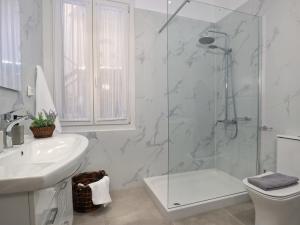 a bathroom with a shower and a toilet and a sink at La Casa Buranella in Lefkada
