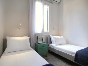 a bedroom with two beds and a window at La Casa Buranella in Lefkada