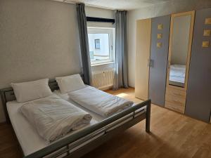 a bedroom with a bed and a window and a door at Apartmenthaus - Mackenbach in Mackenbach