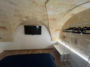 a room with a tv on a stone wall at Messapia Home in Mesagne