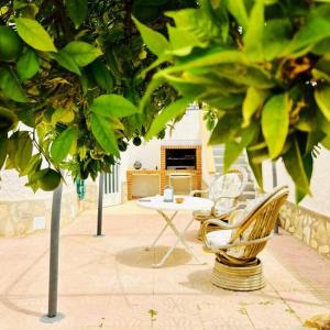 a patio with a table and a chair and a table at Casa Zeus by SunshineClub in Los Alcázares