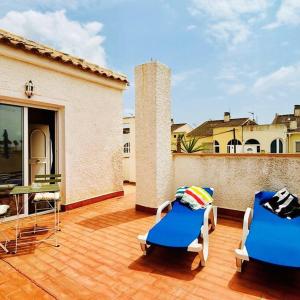 a patio with two chairs and a table on a balcony at Casa Zeus by SunshineClub in Los Alcázares