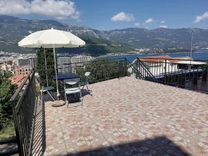 a patio with a table and an umbrella at Guest House Garden in Budva
