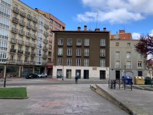 eine Person, die vor Gebäuden eine Straße hinuntergeht in der Unterkunft Forum Evolucion Residence in Burgos