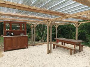 a wooden pavilion with a picnic table and a bench at Au Chat qui Pêche in Thenay +36 photos