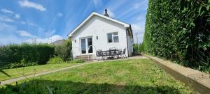 a white house with a bench in a yard at Sunnydale, Cartmel in Cartmel
