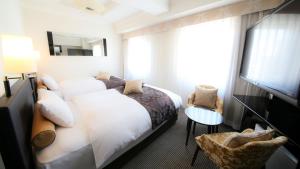 ein Hotelzimmer mit einem Bett und einem Fernseher in der Unterkunft APA Hotel Ikebukuro Eki Kitaguchi in Tokio