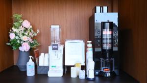 a counter with cosmetics and a vase with flowers at Dormy Inn Aomori Natural Hot Spring in Aomori