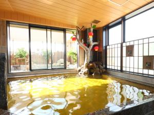 a koi pond in a house with a tree in it at Dormy Inn Aomori Natural Hot Spring in Aomori