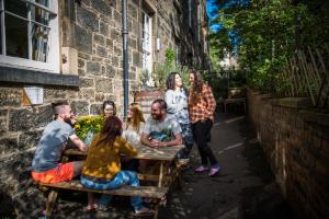 people sitting on a wooden bench at Castle Rock Hostel in Edinburgh