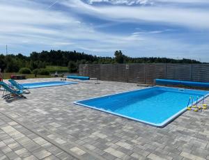 two large swimming pools with blue inflatables on a patio at AgroBorcz in Borcz