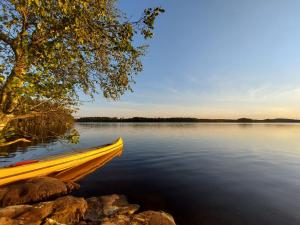 una barca gialla in riva al lago di Glamping & Floating Sauna a Rejböle