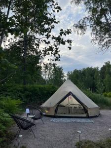 una tenda con un tavolo e due sedie in un parcheggio di Glamping & Floating Sauna a Rejböle