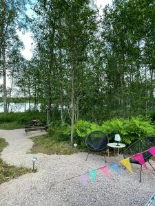 due sedie e un tavolo con bandiere in un parco di Glamping & Floating Sauna a Rejböle Altre 15 foto