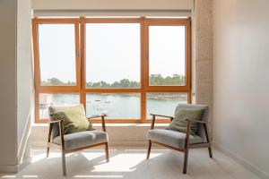 two chairs and a table in front of a window at Apartamento Serea in Villanueva de Arosa