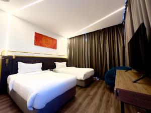 a hotel room with two beds and a desk at Regatta at Kozi Square Kuching in Kuching +54 photos