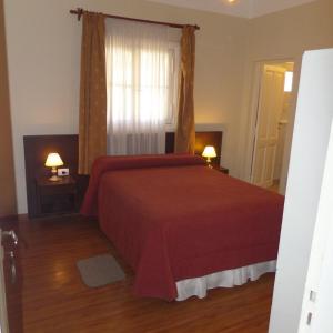 a bedroom with a red bed and a window at Hotel Radio in Valle Hermoso