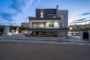 ein großes weißes Haus mit dunklem Dach in der Unterkunft Mons Villa in Kalathas