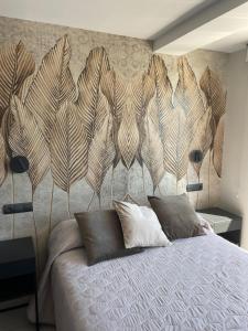 a bedroom with a bed with a large feather headboard at Apartamento Serea in Villanueva de Arosa